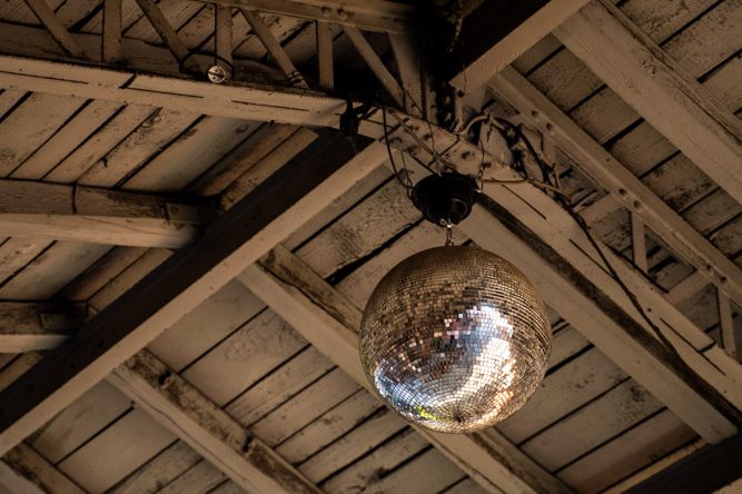 Beziehungen zelebrieren Discokugel hängt an einer rustikalen Holzdecke.